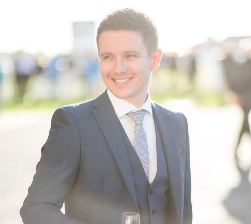 A well-dressed young man enjoys getting dressed up for the races