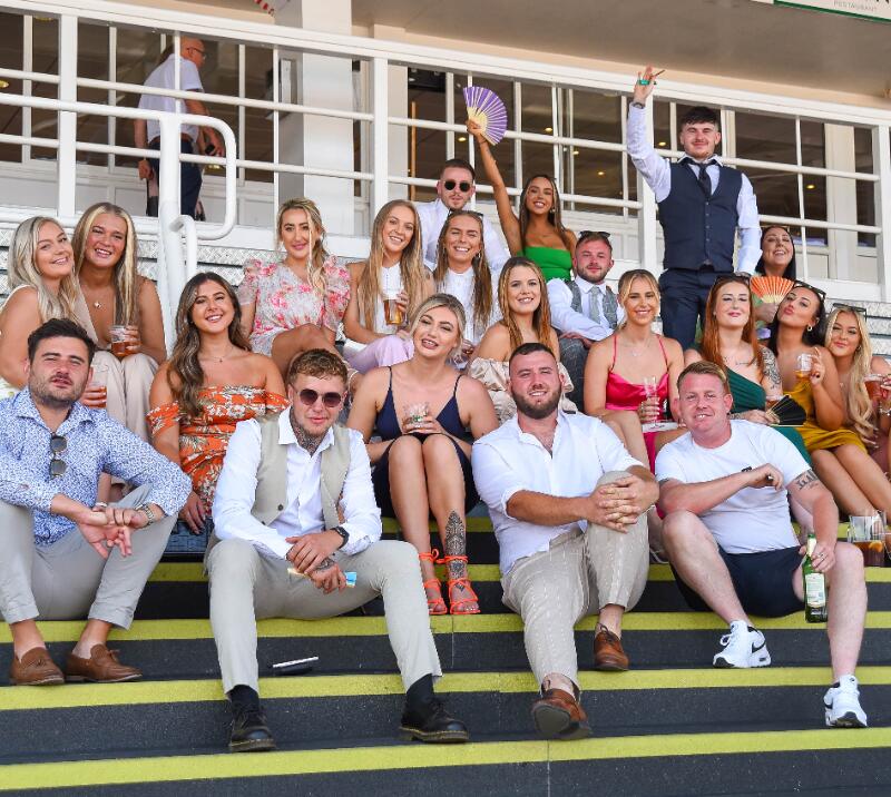 A large group of friends sat on the grandstand steps at Southwell Races