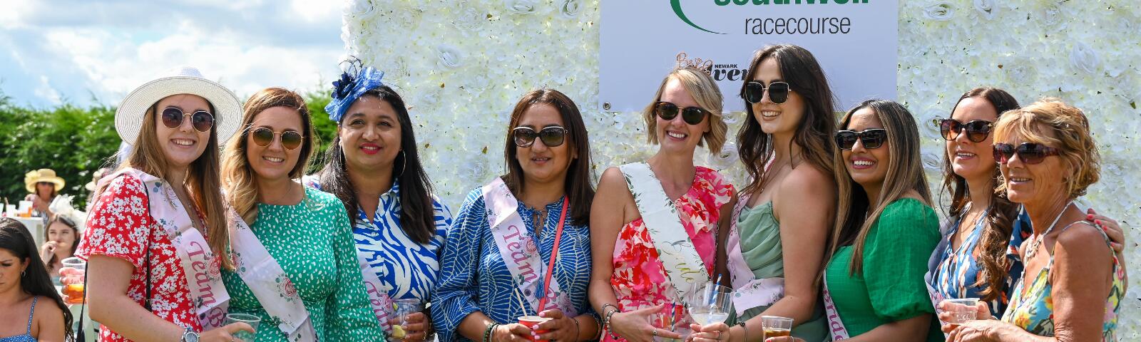 A hen party poses in front of the flower wall at Southwell Racecourse
